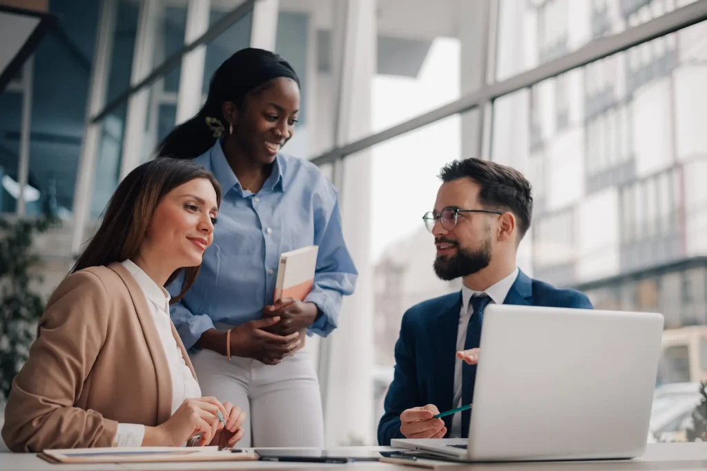 Business team discussing strategy on laptop in modern office